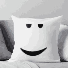 a pillow with a smiling face on it is sitting on a couch .