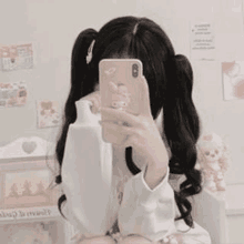 a girl is taking a selfie with her cell phone .