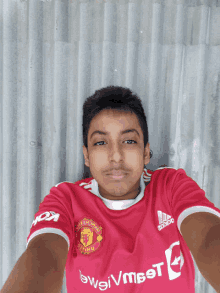 a boy wearing a red manchester united jersey