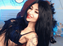 a woman with long black hair and a tattoo on her arm