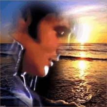 a close up of a man 's face looking out over the ocean at sunset .