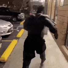 a man is running down a sidewalk with a bag on his back .