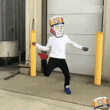 a man in a costume is jumping in the air while wearing a bucket on his head .