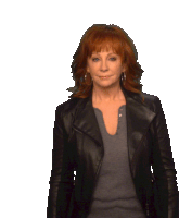 a woman with red hair is wearing a black jacket