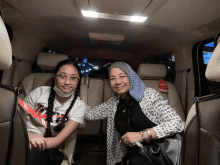 a woman and a girl are posing for a picture in a car