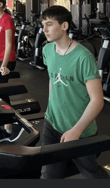 a boy wearing a green shirt that says " air jordan " is running on a treadmill