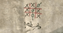 a tic tac toe game is drawn on a wall with arabic writing