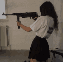 a girl holding a gun with riot written on her shirt