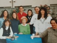 a group of people posing for a picture with one woman wearing a green sweater with the letter y on it