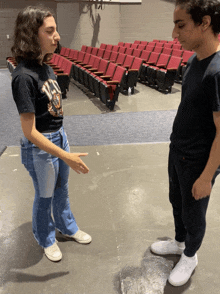 a man and a woman are standing in front of an auditorium