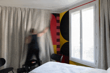 a blurred image of a person behind a curtain in a bedroom