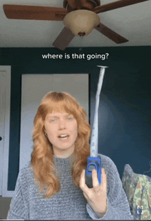 a woman with red hair is holding a tape measure in front of a ceiling fan and the words " where is that going "