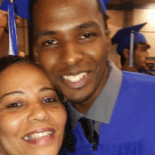 a man in a graduation cap and gown poses for a photo with a woman