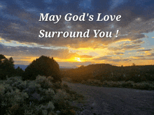 a sign that says may god 's love surround you with a sunset in the background