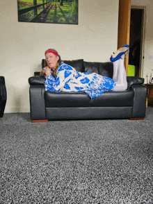 a woman is laying on a black couch with her feet up