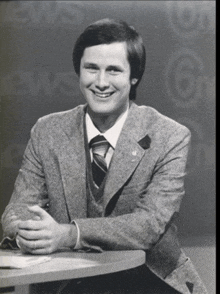 a man in a suit and tie is smiling in front of a news 6 sign