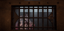 a woman is behind bars in a jail cell