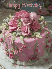 a pink birthday cake decorated with pink roses and white flowers