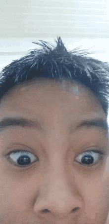 a close up of a person 's face with a surprised look on his face