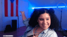 a woman with curly hair is smiling in front of a puerto rican flag