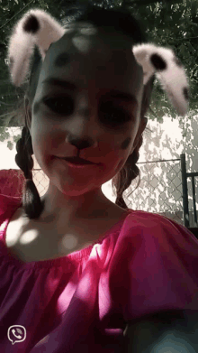 a girl in a pink dress with bunny ears on her face