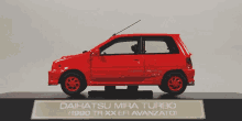 a model of a red daihatsu mira turbo is on display