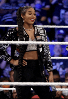 a woman in a sequined jacket stands in a boxing ring