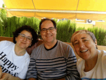 a woman wearing a white shirt that says happy love smiles with two other people