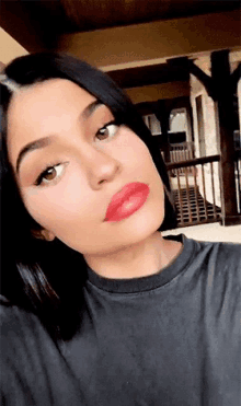 a close up of a woman 's face with red lipstick on her lips .