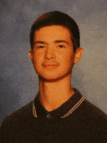 a young man wearing a black polo shirt with a white collar