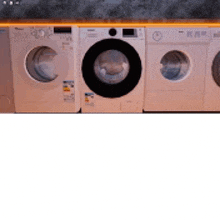 a row of washing machines are lined up on a counter