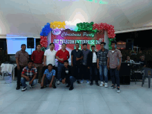 a group of men pose in front of a sign that says christmas party jrt telecom enterprise inc.