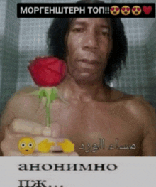 a shirtless man is holding a red rose with a smiley face on it