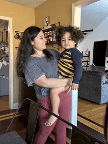 a woman holds a child in her arms in front of a shelf with a sign that says " wanted " on it