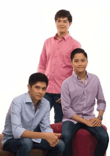 three young men in pink shirts are posing for a photo