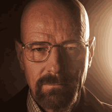 a bald man with glasses and a beard looks serious