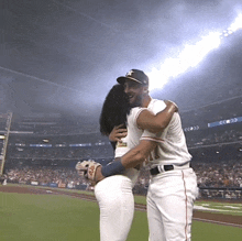 a baseball player with the number 11 on his jersey is hugging a woman