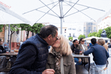 a man kissing a woman under an umbrella that says ' aguila ' on it