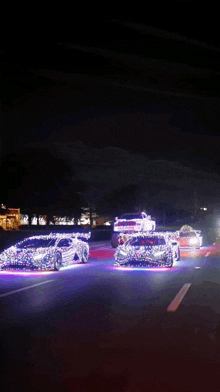 a group of cars are driving down a road at night