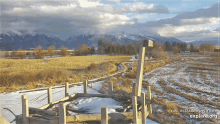 a snowy field with mountains in the background and the words explore.org on the bottom