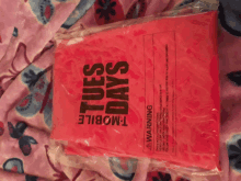 a pink plastic bag that says tuesdays on it