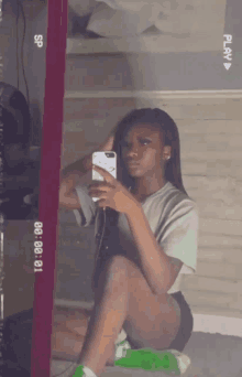 a girl is taking a selfie in front of a mirror that says play on the bottom