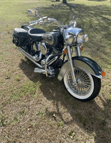 a black and silver motorcycle is parked in a grassy field