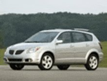 a silver car is parked on the side of a road .