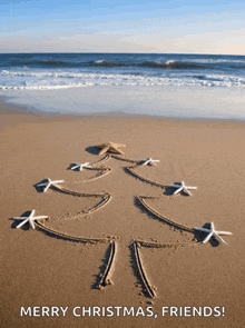 a christmas card with a tree drawn in the sand and the words merry christmas friends