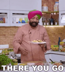 a man in a turban is holding a plate of food with the words " there you go " below him