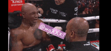 a man in a boxing ring with a purple sticker that says @waxxxi on it