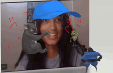 a woman wearing a blue hat is surrounded by a koala and a lizard