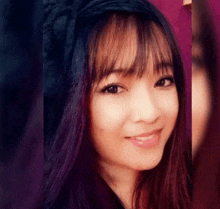 a close up of a woman 's face with long hair and bangs .