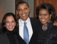 a man and two women are posing for a picture and the man is wearing a blue tie